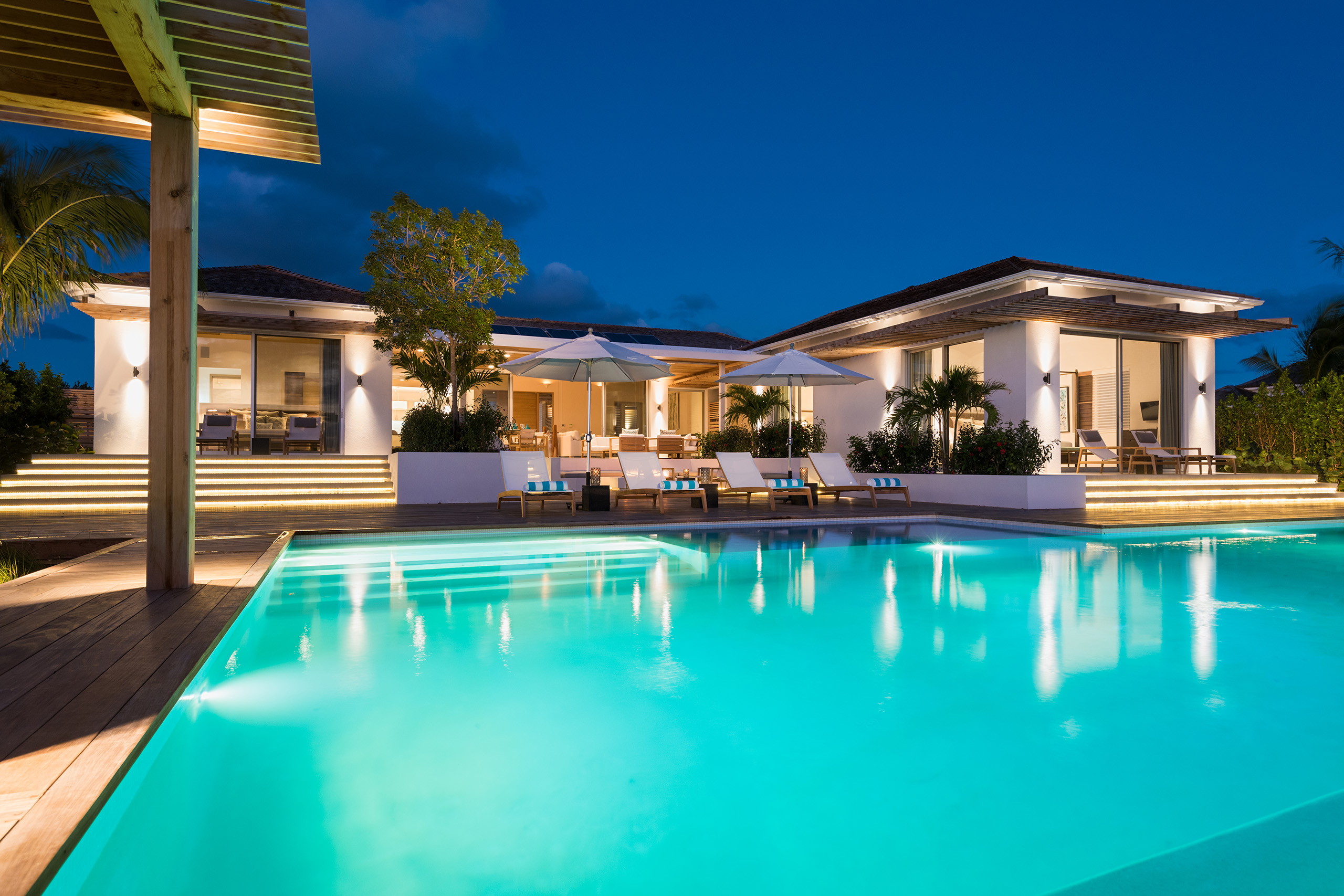 View of Hesperides House at night, looking back across the swimming pool