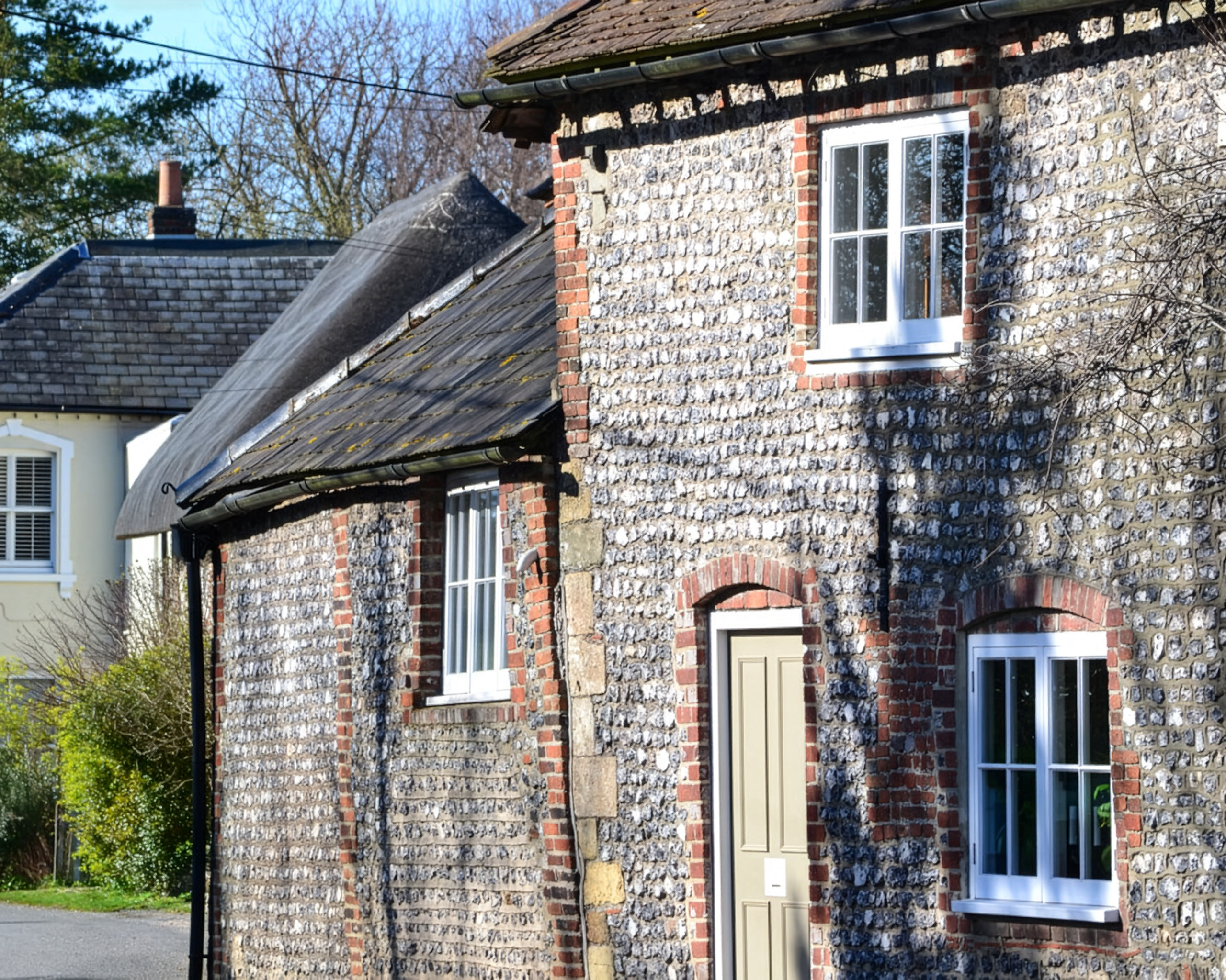 Traditional flint construction, Charlton - centuries-old Sussex buildings demonstrate material durability. Original image by David Martin, CC BY-SA 2.0, Link, via Wikimedia Commons