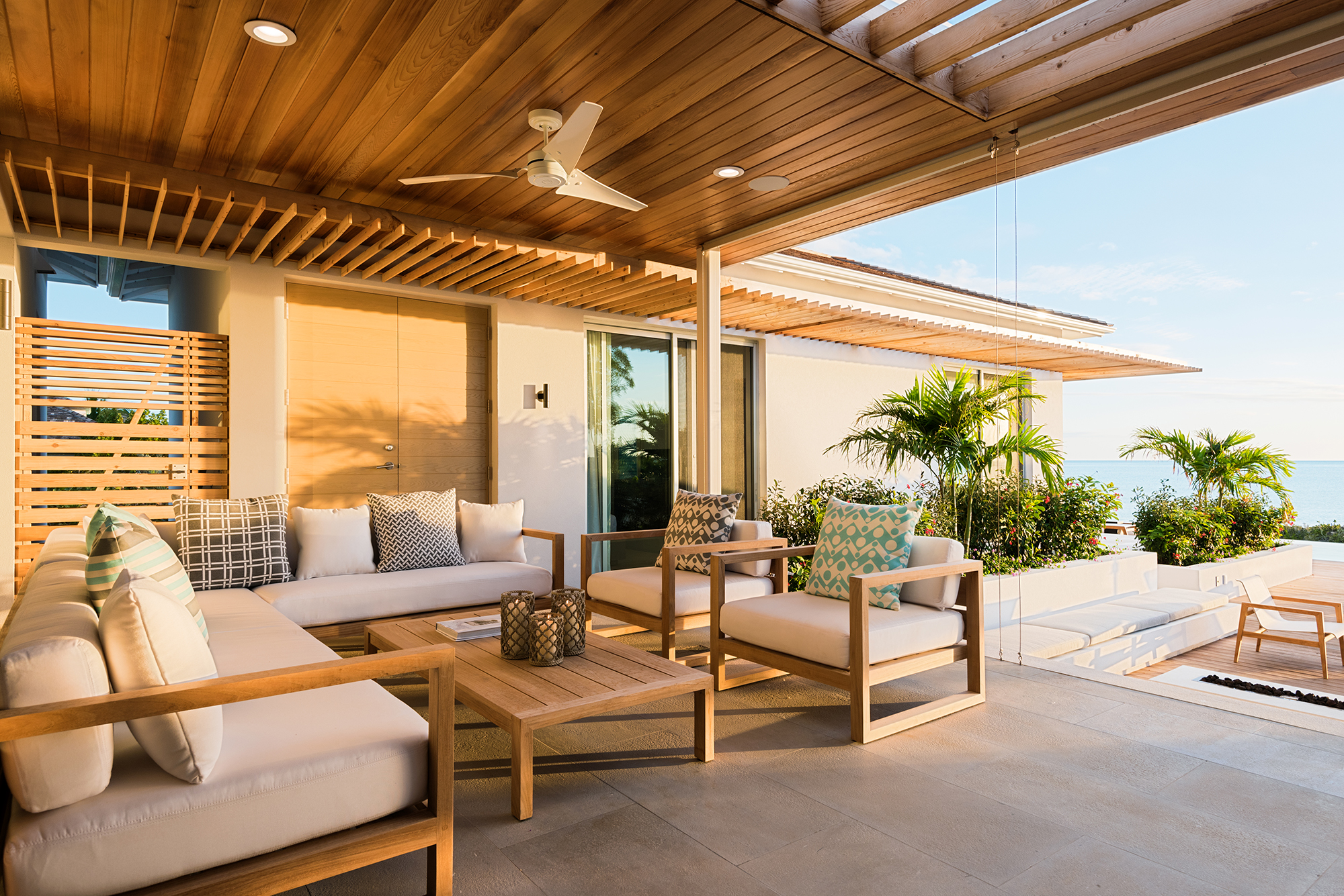 A photograph of Hesperides House in the Turks and Caicos Islands. Deep canopies and pergola elements shade from the sun, while breezeways and ceiling fans help air flow.